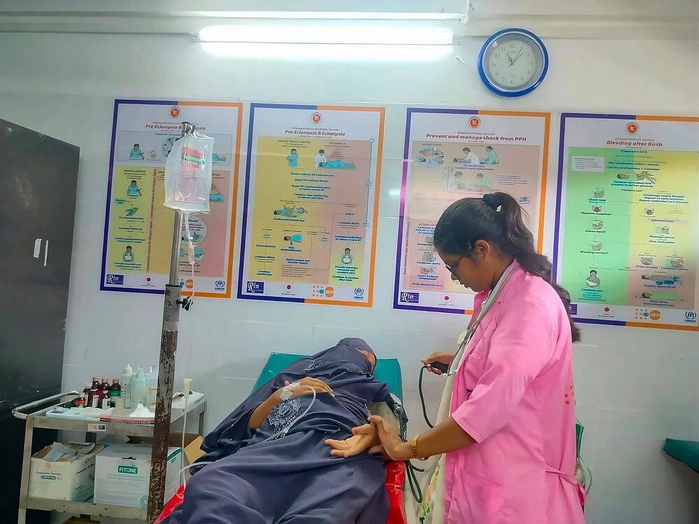 Arafin Mim measures a woman’s blood pressure.