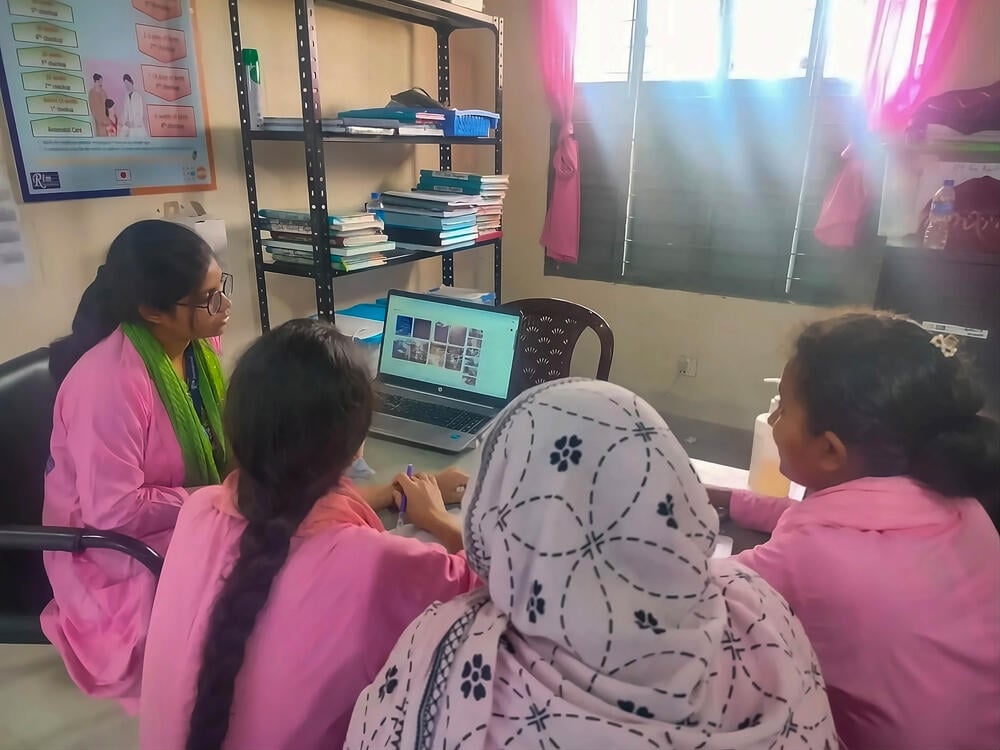 As a supervisor, Arafin Mim shows midwives Ashra Begum, Ayenu Khai, Chompa Rani Kor videos on best practices of care as a part of the ongoing mentoring of her team she manages.