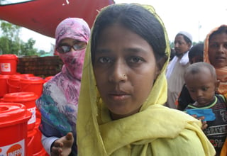 A Rohingya woman receives a UNFPA Dignity Kit with clothing and personal hygiene items
