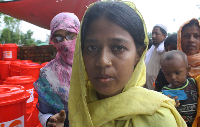 A Rohingya woman receives a UNFPA Dignity Kit with clothing and personal hygiene items