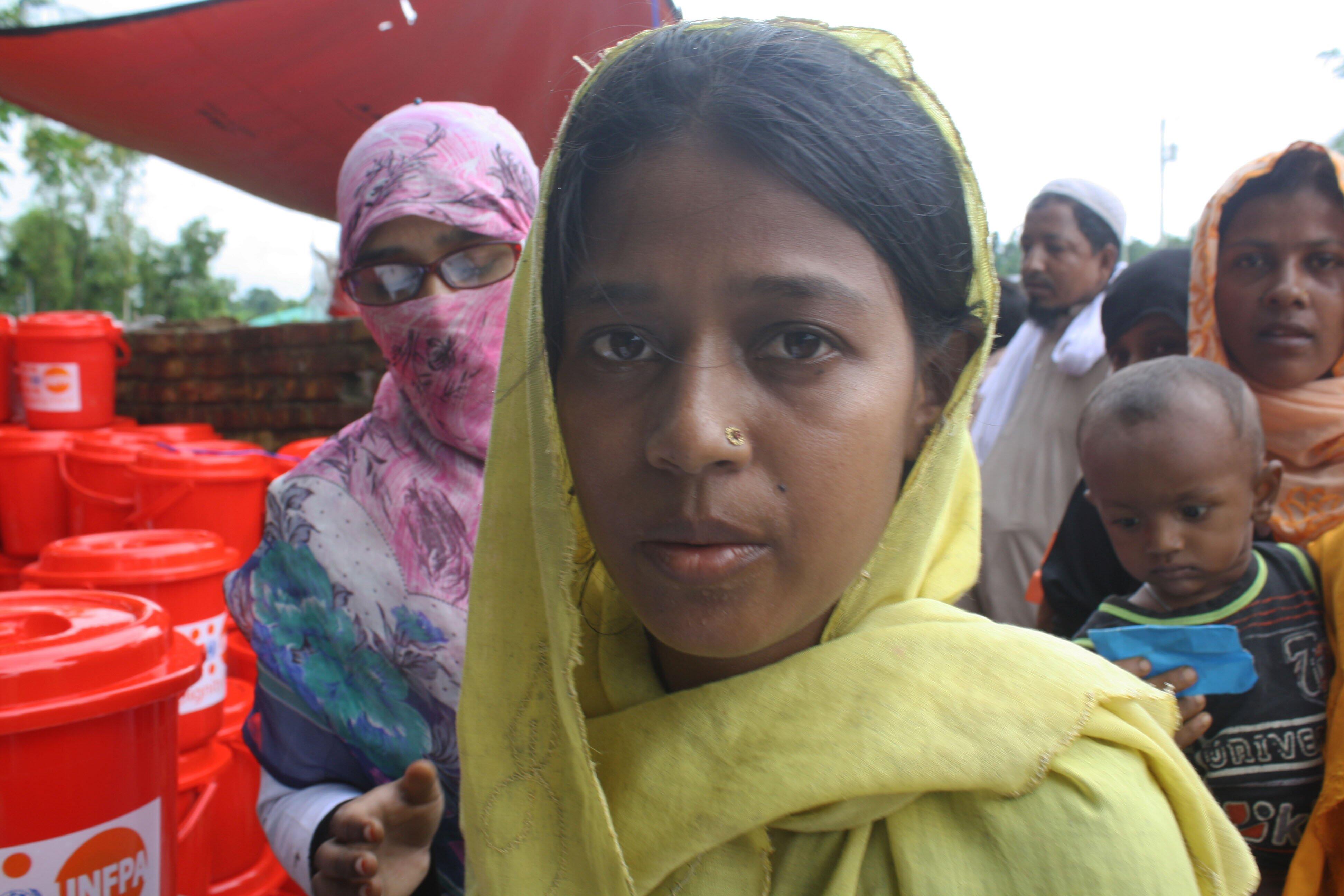 A Rohingya woman receives a UNFPA Dignity Kit with clothing and personal hygiene items